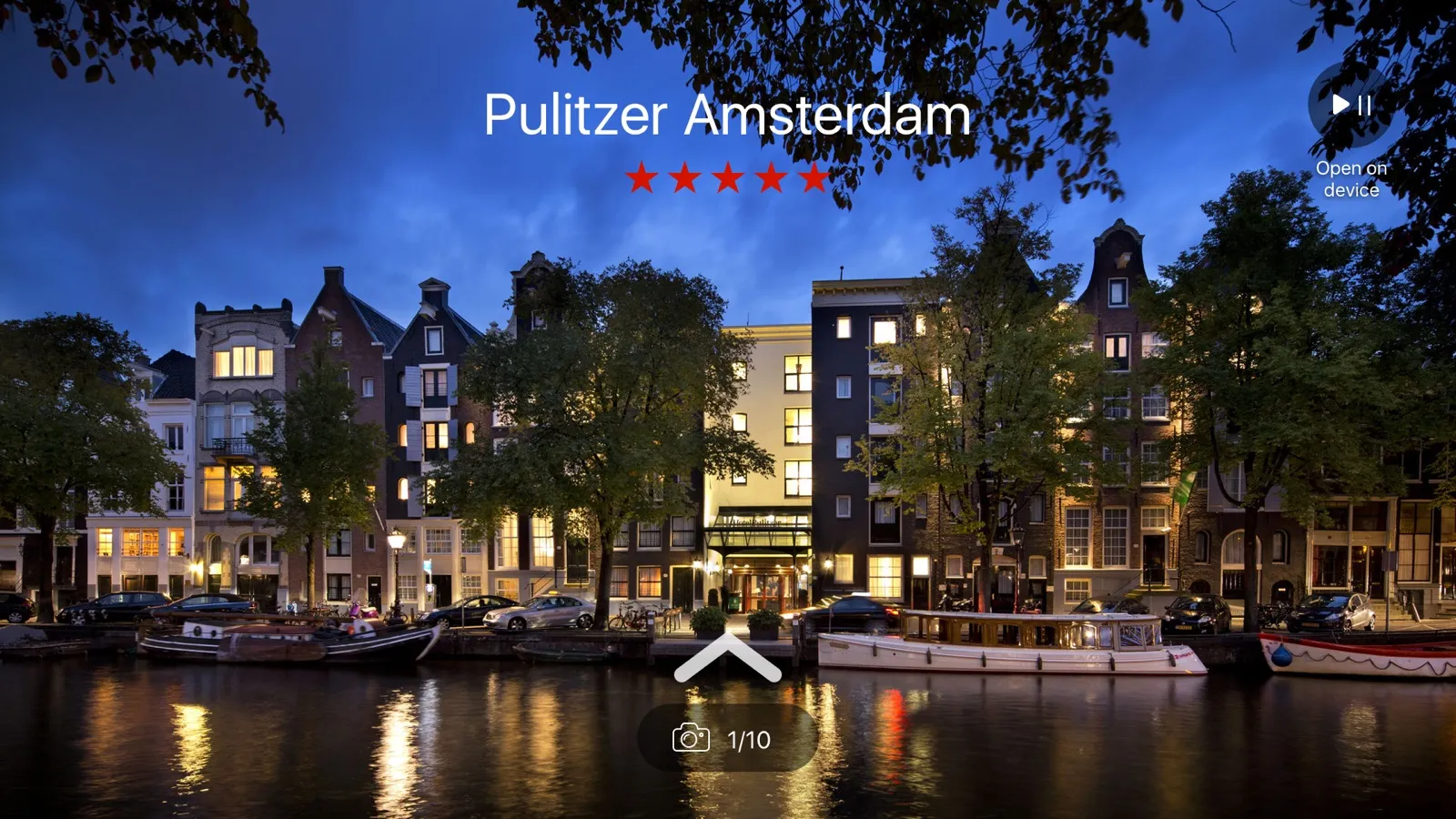 An Apple TV screen of the Pulitzer Amsterdam at night, five red stars, a play control, and Open on device.