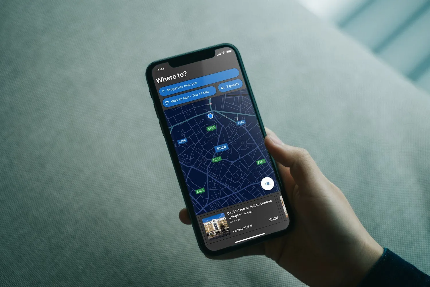 The same map in the dark theme. The streets are navy, the prices are green, and the hotel card is dark.